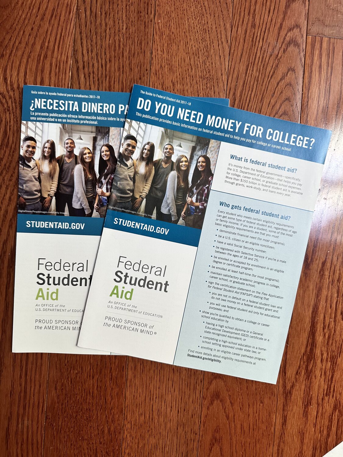 Do You Need Money for College? guides, English and Spanish editions, fanned on a wood table